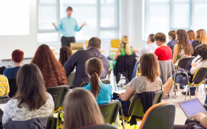 Classroom with teacher at front and adult students