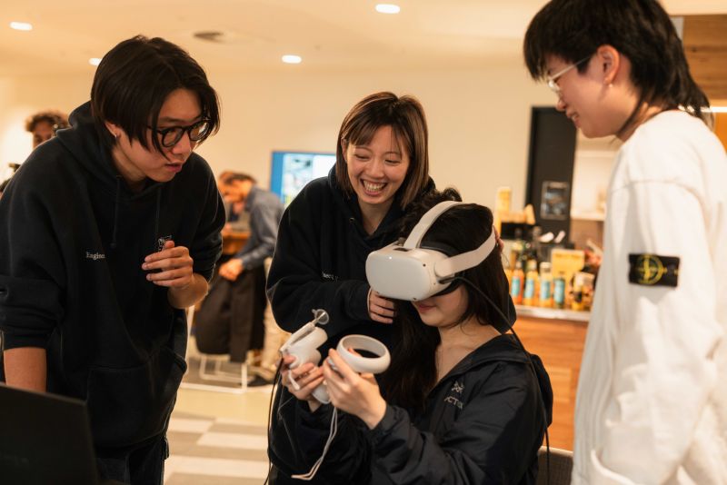 People laughing, one in VR headset.