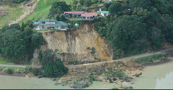 Houses on edge of cliff that has collapsed due to landslide