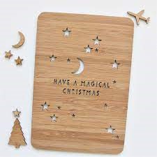 A laser cut Christmas card, with a starry night pattern and the text 'Have a magical Christmas' engraved upon it.