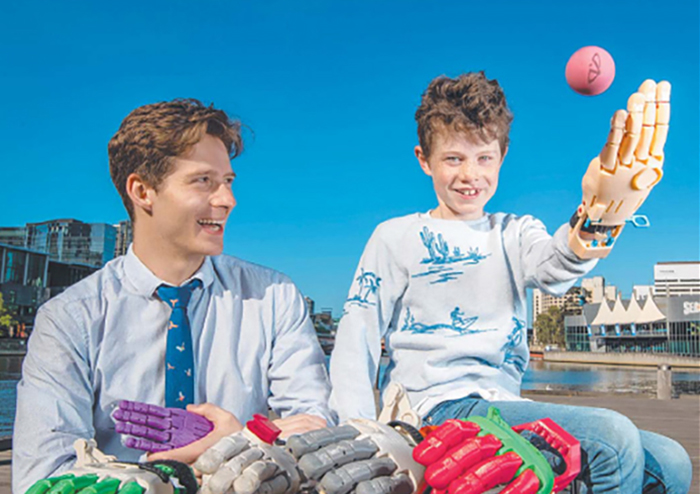 University of Melbourne engineering alum Matt Collinson with Mikko, 8, and his 3D-printed prosthetic hand