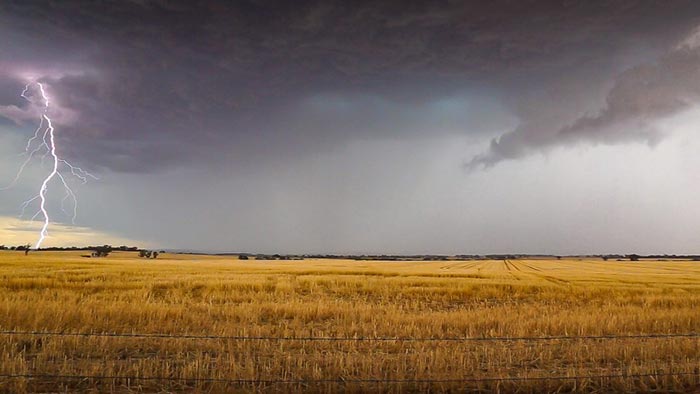 Country field with storm in background and lightning on left of image