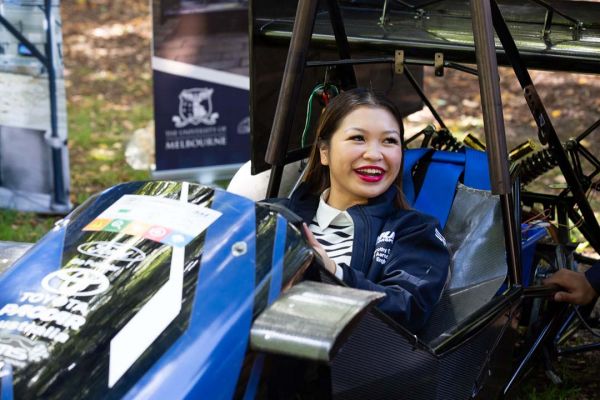 Female student sits in the Melbourne Uni Rover Team club racecar