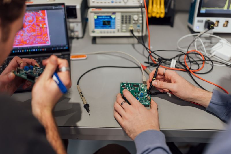 Hands working on circuit boards