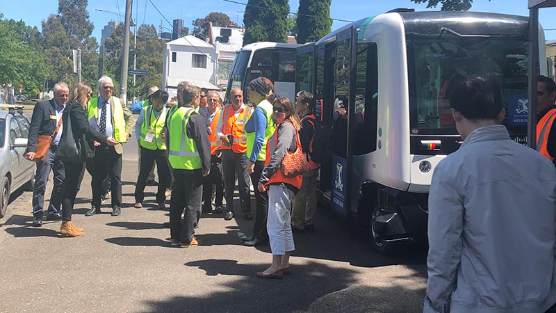 Delegateswearing hi-vis being shown the AIMES autonomous bus