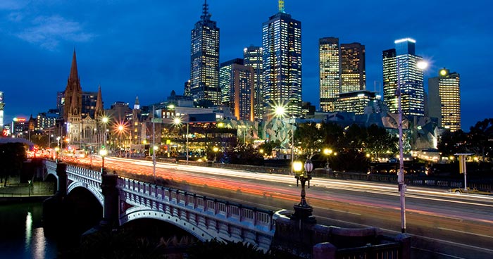 Melbourne skyline at night viewed from Southbank with blurred traffic over Princes Bridge