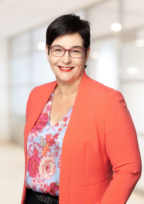 A woman with short black hair and glasses