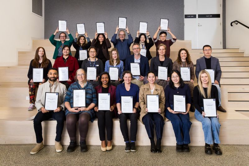 Group of people holding award certificates.