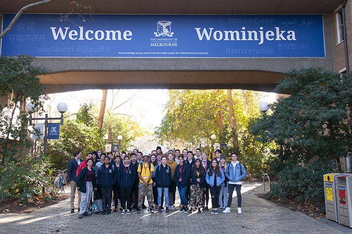 VIEWS students gathered under Wominjeka sign on University of Melbourne campus