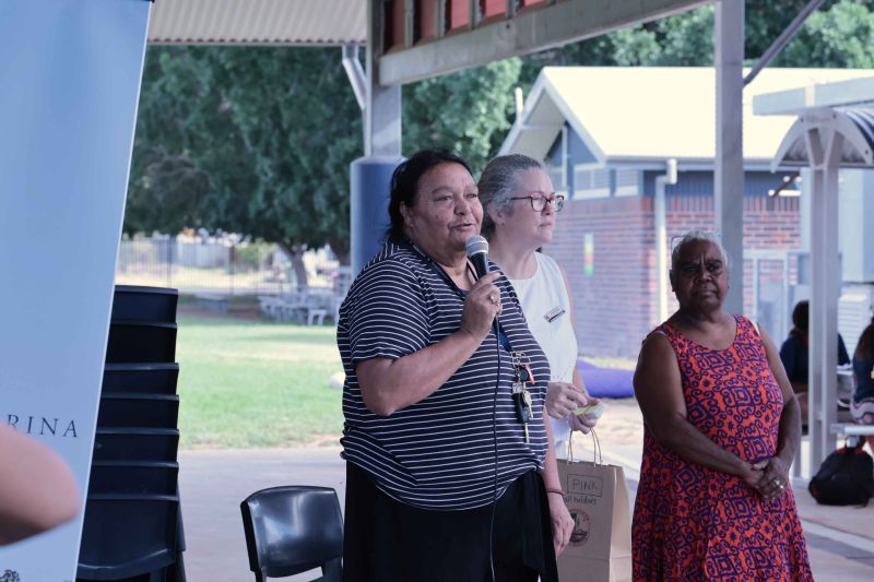 Three people standing during speech.
