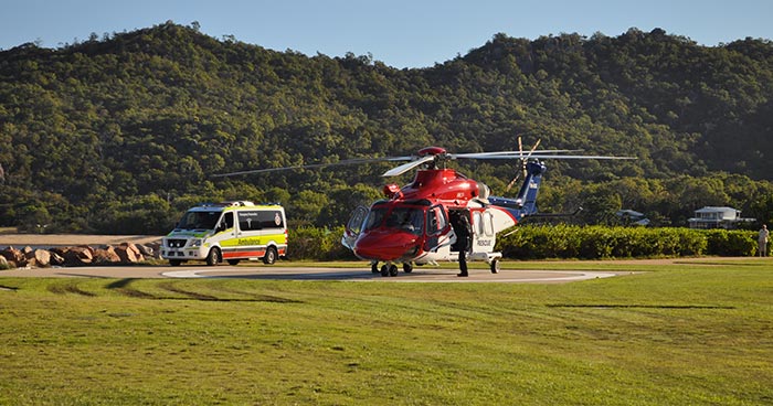 Ambulance van and helicopter next to each other with mountains in background