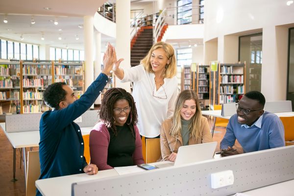 Students giving each other a high five in a library