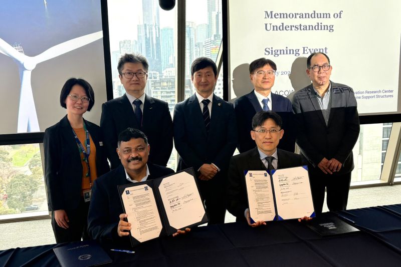 Group of people holding up signed MoU