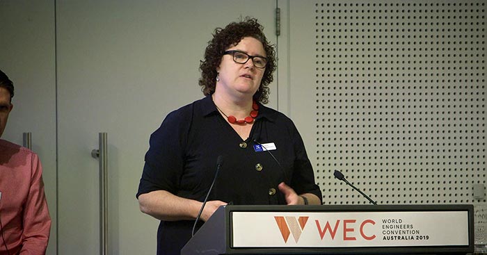 Professor Andrea O'Connor presenting at podium at WEC Breakfast