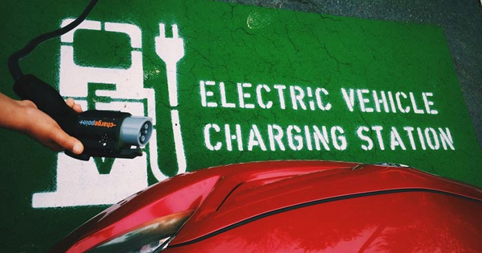 Electric car charger with sign indicating charging station