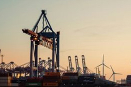 Image of cranes at dock and wind turbines in background