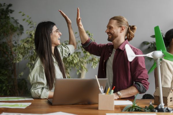 Two business people giving each other a high five 