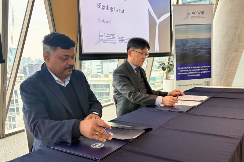 Two people signing MoU.